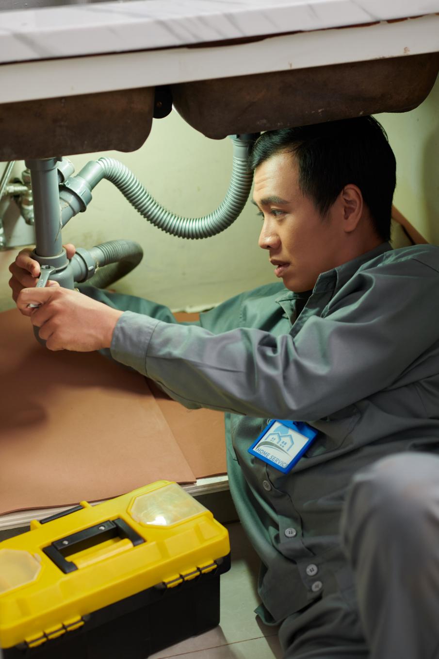 Plumber fixing kitchen sink faucet